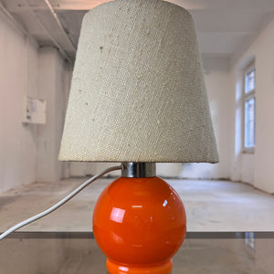 Tischlampe orange mit leuchtendem Glasfuß