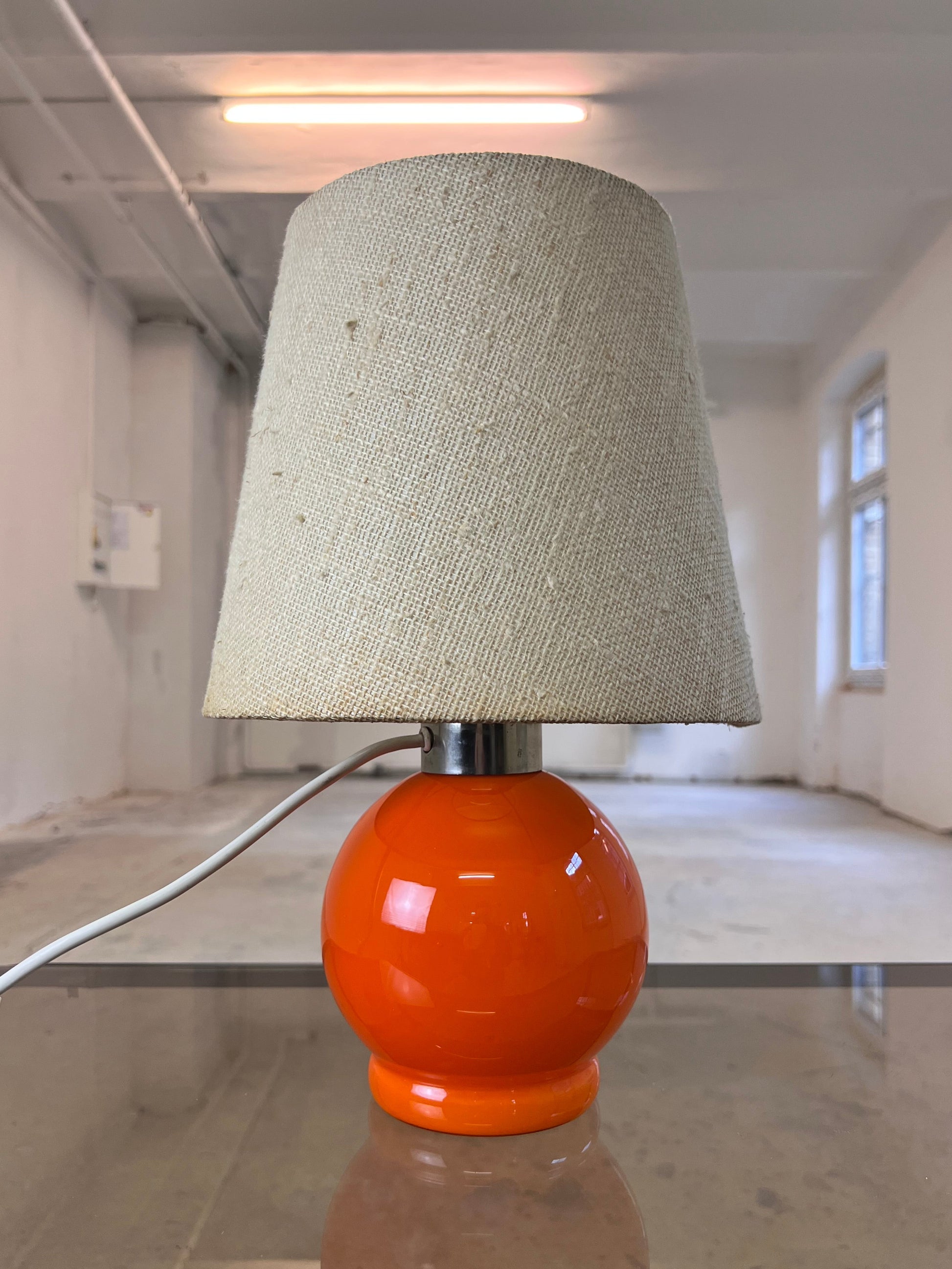 Tischlampe orange mit leuchtendem Glasfuß