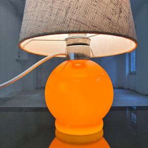 Tischlampe orange mit leuchtendem Glasfuß