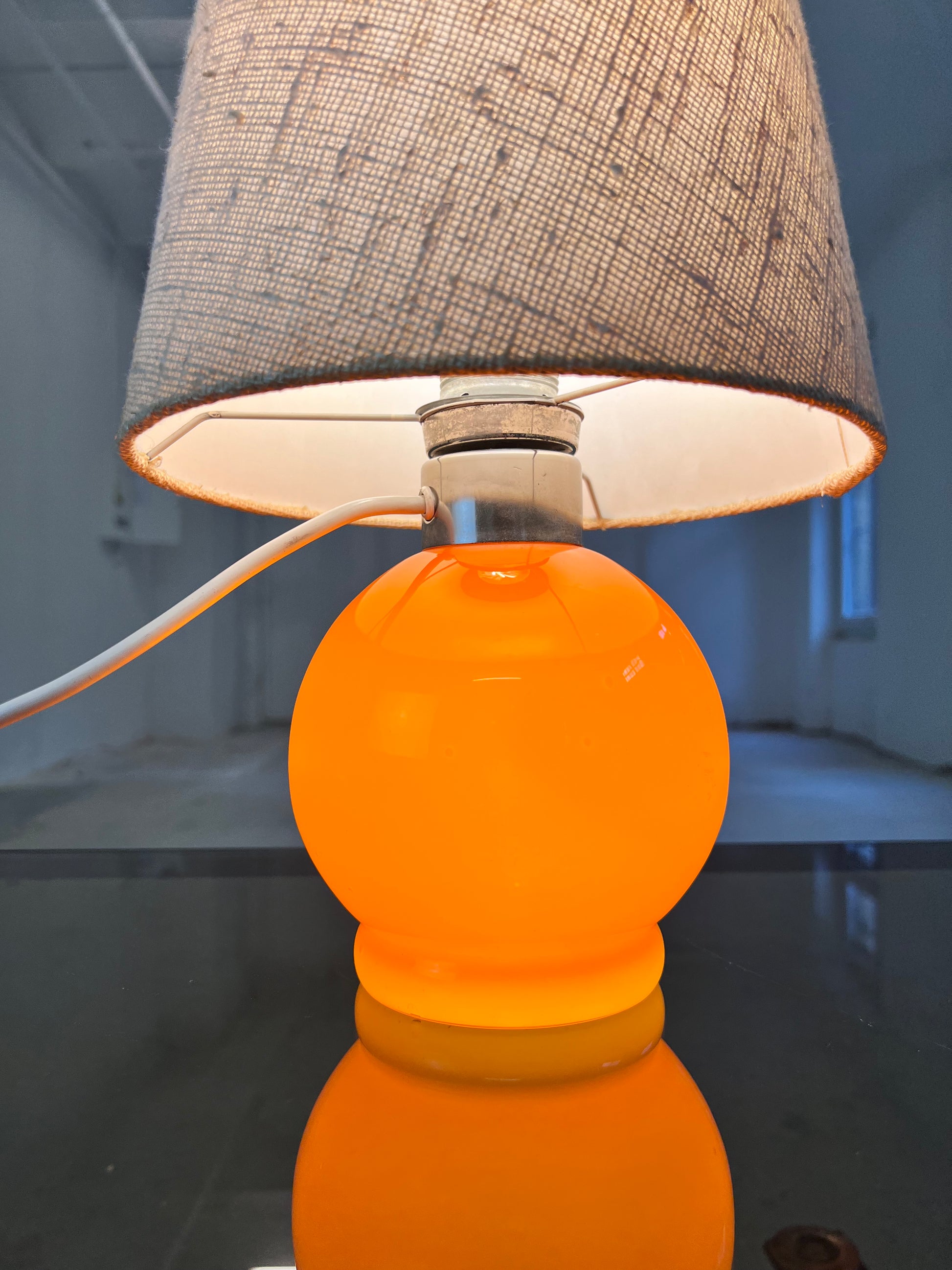 Tischlampe orange mit leuchtendem Glasfuß