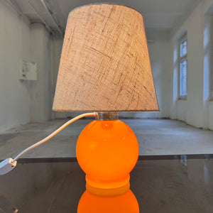 Tischlampe orange mit leuchtendem Glasfuß