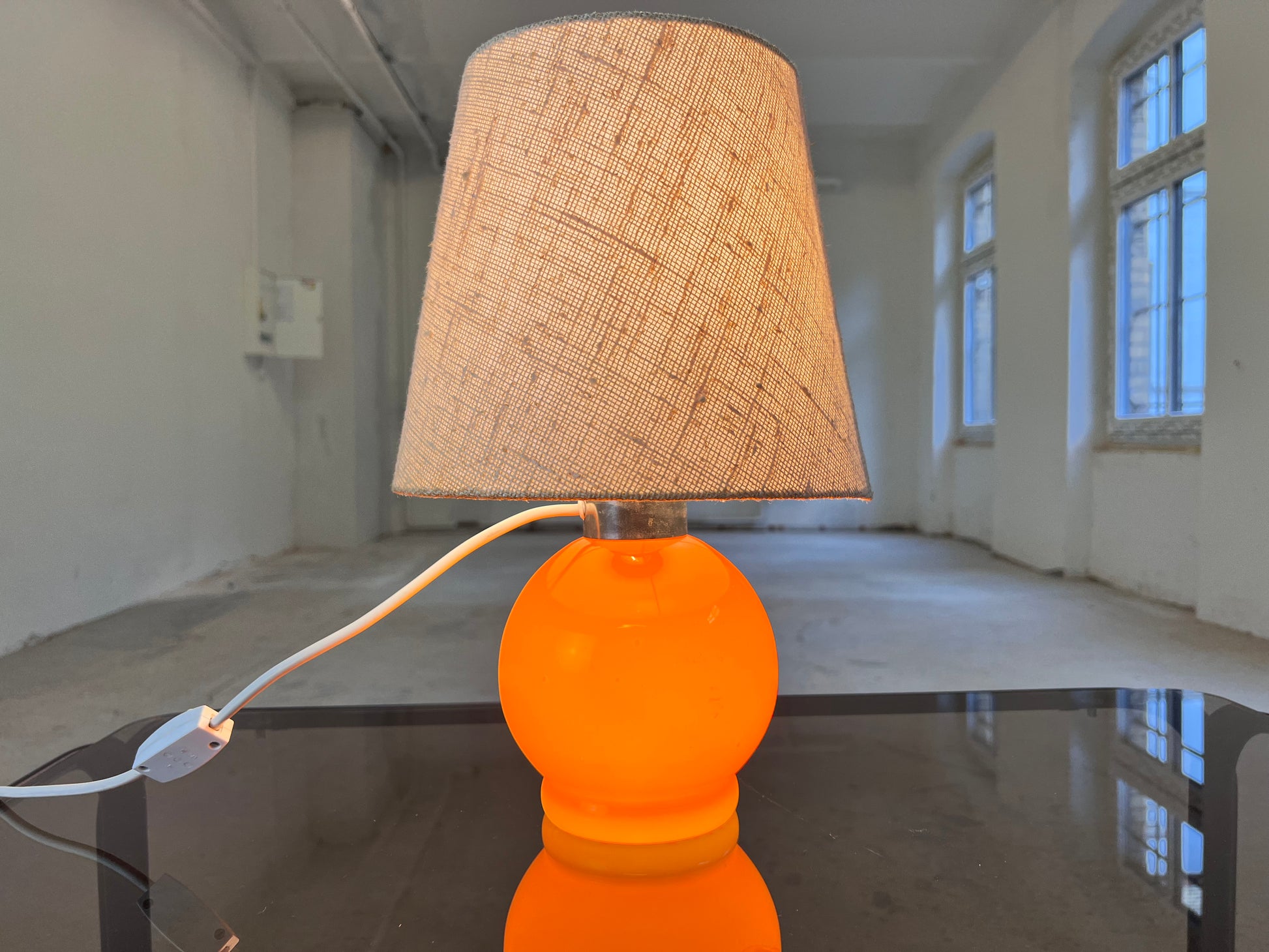 Tischlampe orange mit leuchtendem Glasfuß