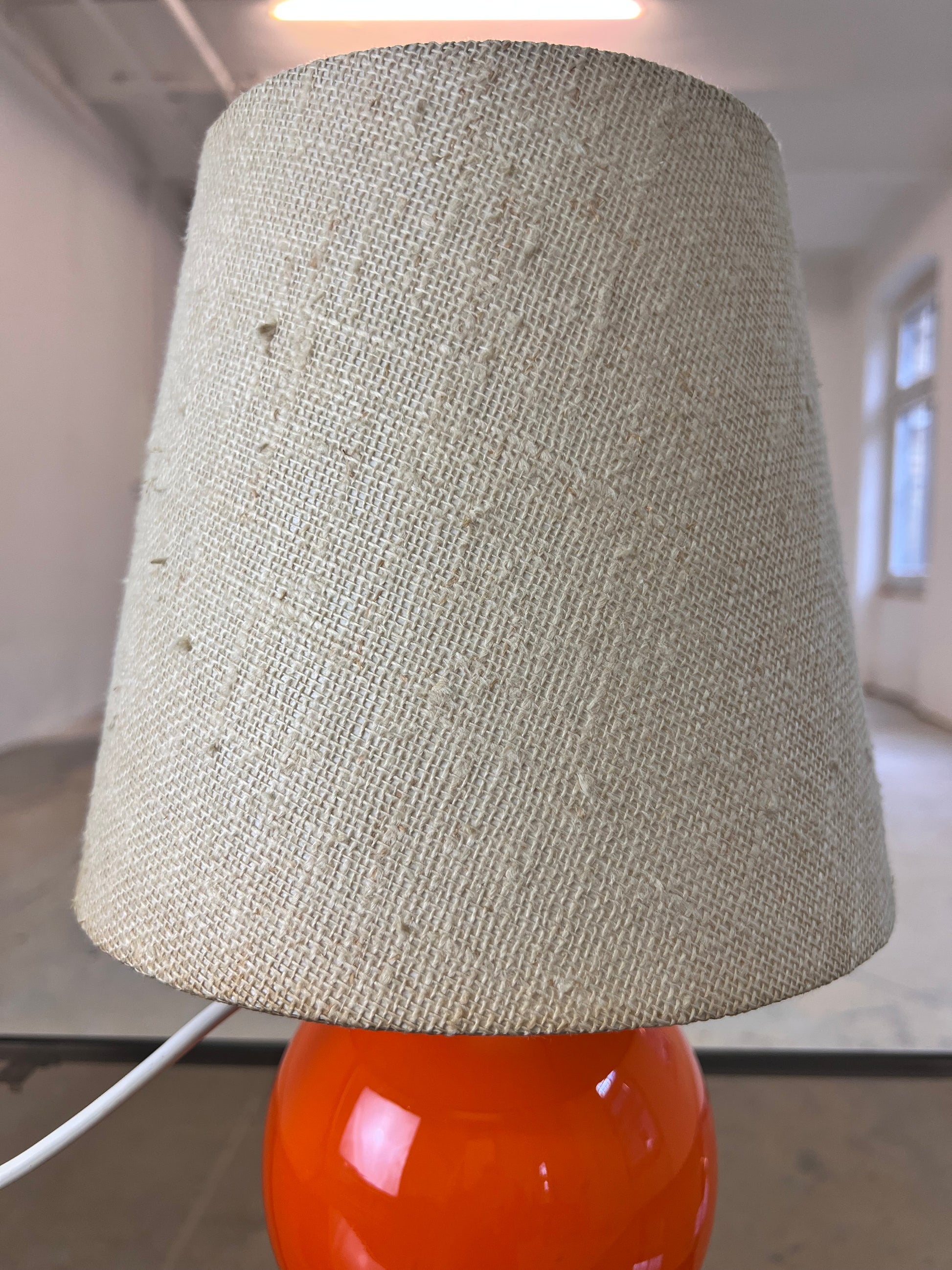 Tischlampe orange mit leuchtendem Glasfuß
