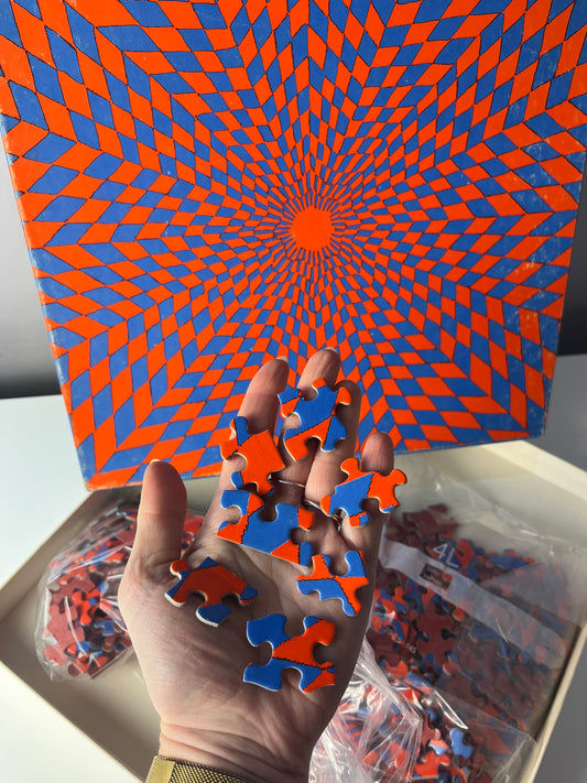 Puzzle "Ambiguous Corolla" rot blau von Claudia Carrel für Springbok Editions