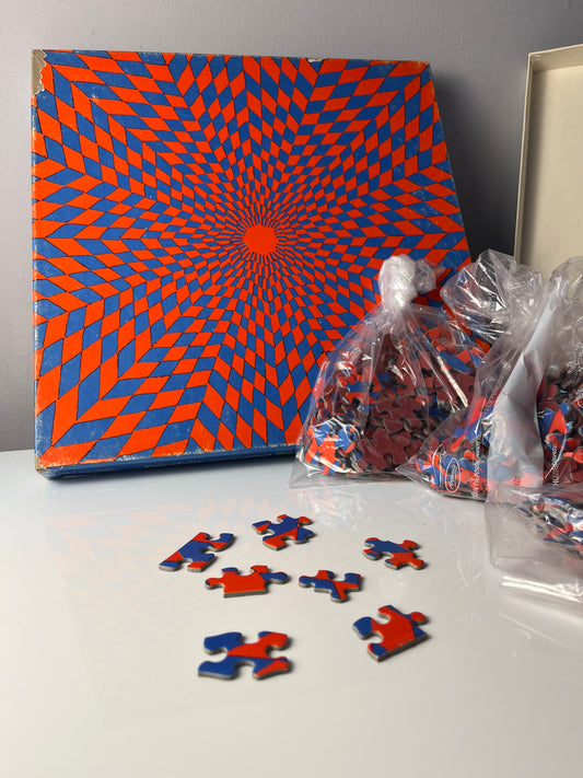 Puzzle "Ambiguous Corolla" rot blau von Claudia Carrel für Springbok Editions