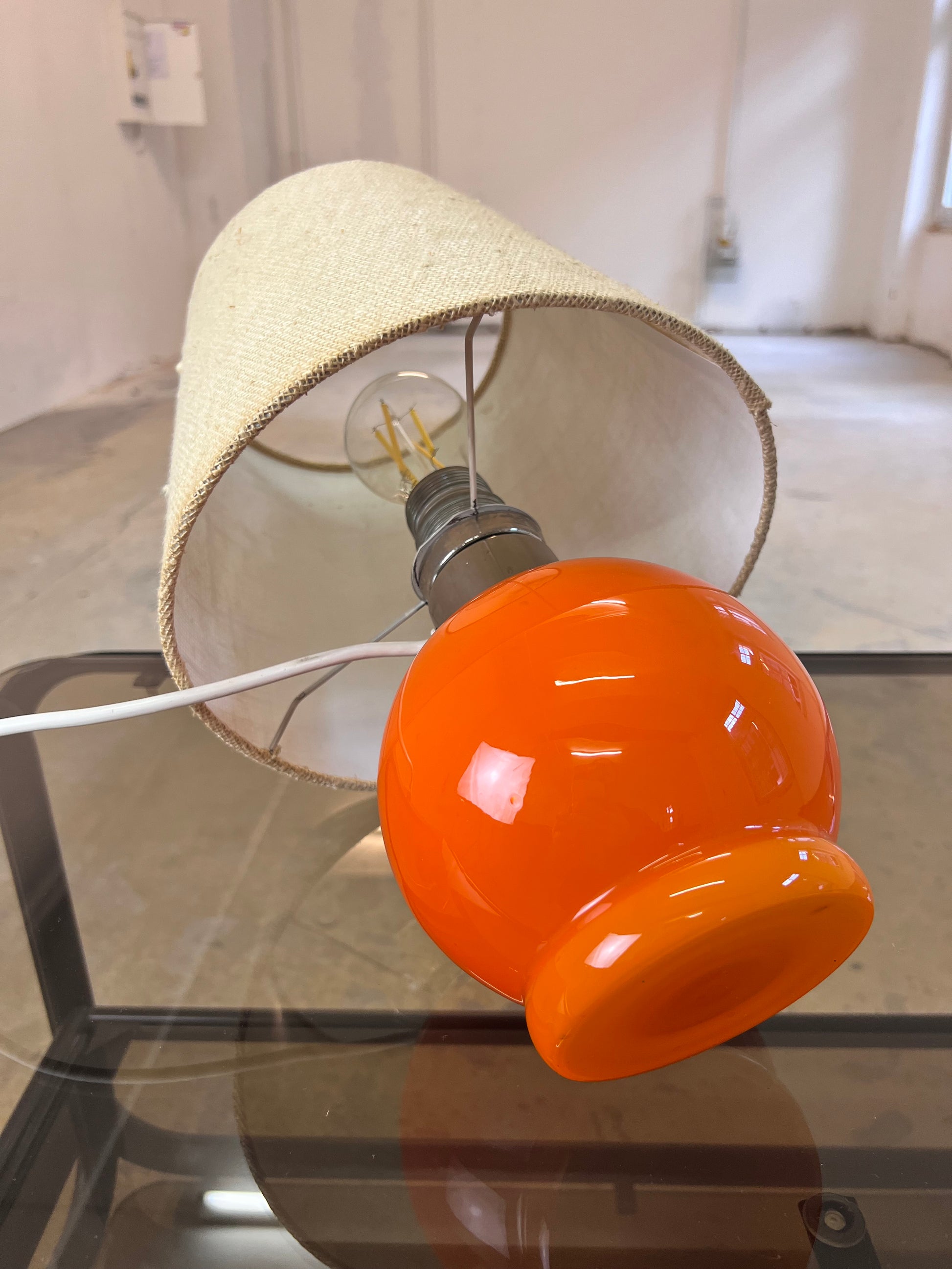 Tischlampe orange mit leuchtendem Glasfuß