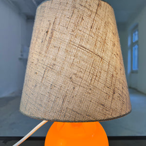 Tischlampe orange mit leuchtendem Glasfuß