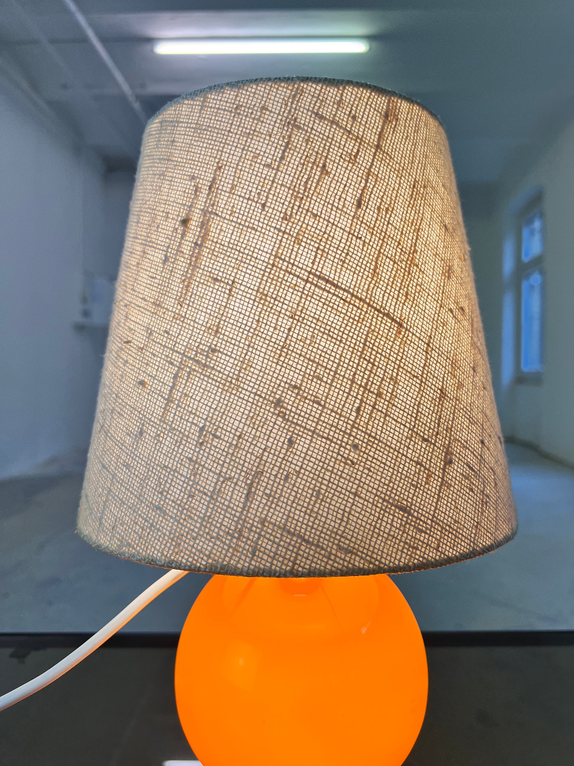 Tischlampe orange mit leuchtendem Glasfuß