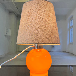Tischlampe orange mit leuchtendem Glasfuß