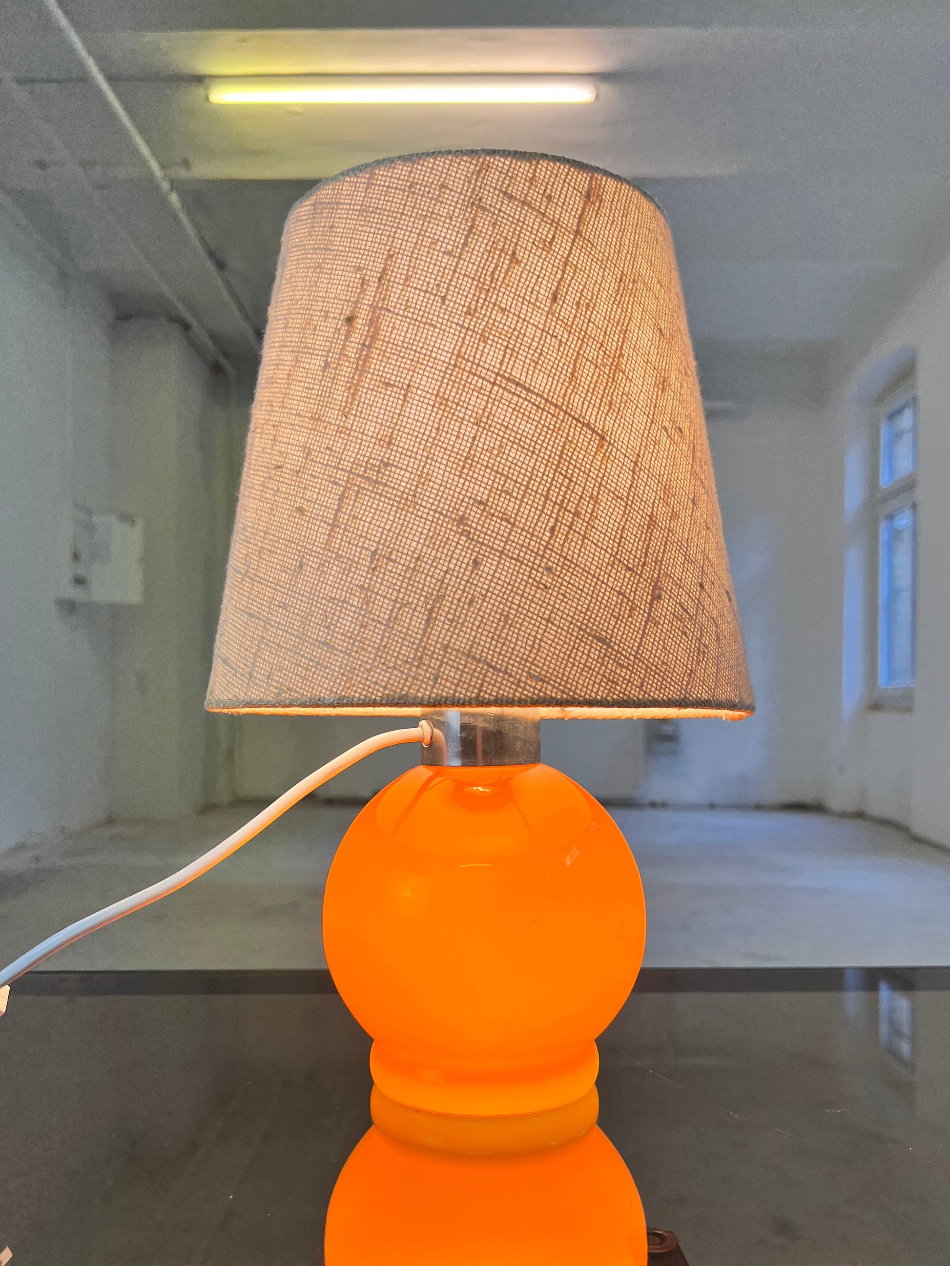 Tischlampe orange mit leuchtendem Glasfuß