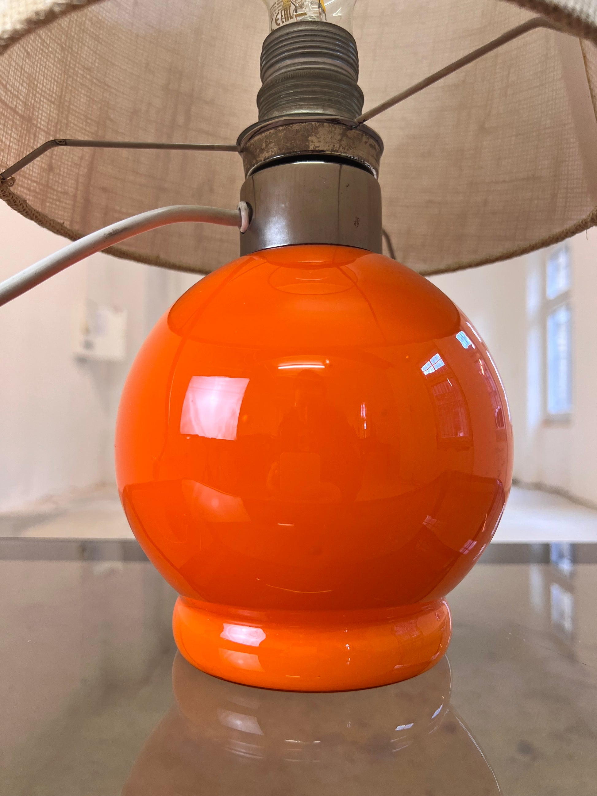 Tischlampe orange mit leuchtendem Glasfuß
