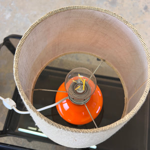 Tischlampe orange mit leuchtendem Glasfuß